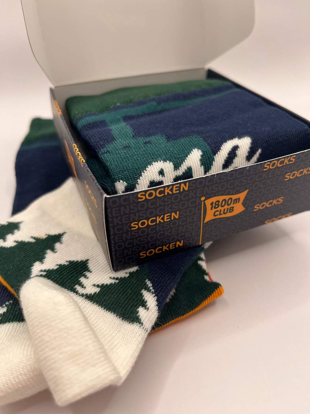Unisex Arosa knit socks presented in a custom 1800m Club gift box.