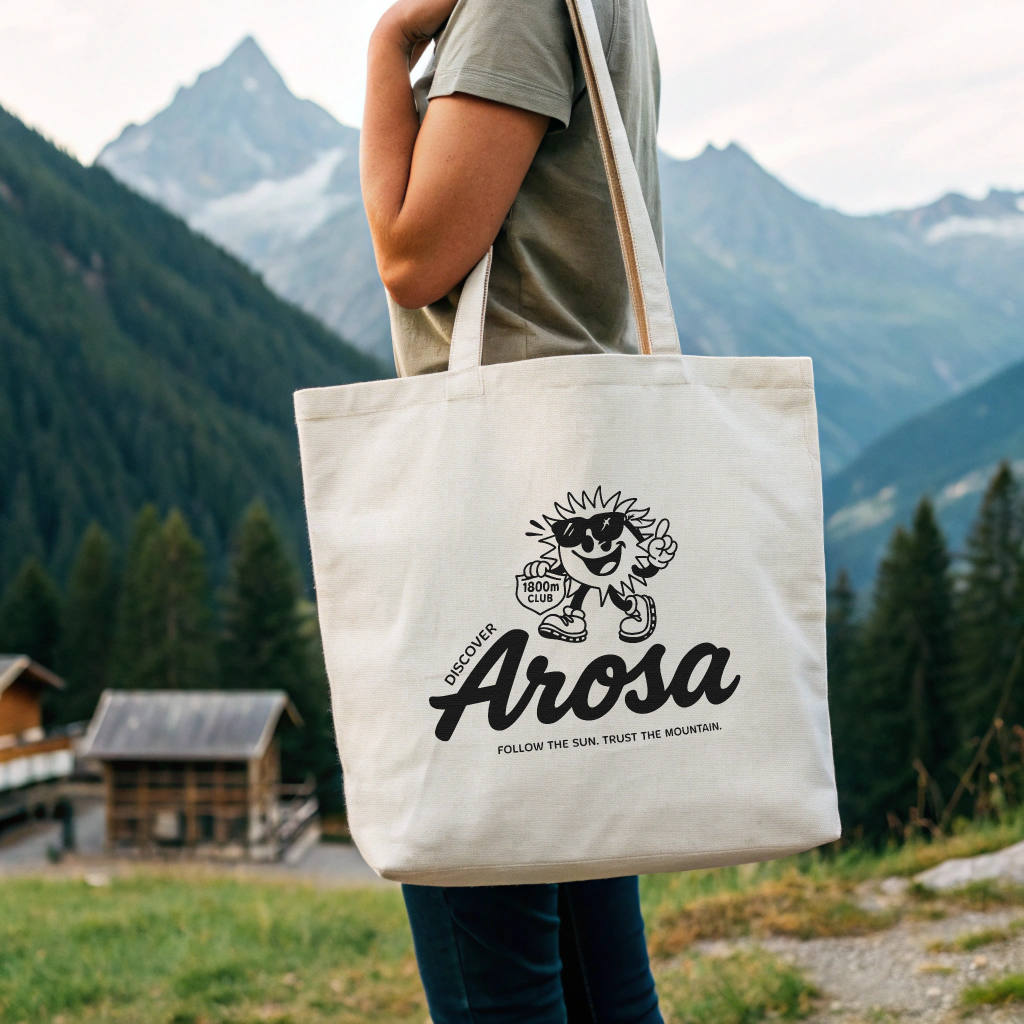 Discover Arosa x 1800m Club Tote Bag, organic cotton canvas tote with Ray mascot and Arosa logo, screenprinted in Arosa, Switzerland
